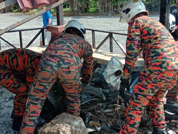 Anggota bomba menyelamatkan pasangan suami isteri yang maut selepas dirempuh sebuah kereta dan seorang daripadanya terperosok di bawah runtuhan pondok bas di Batu 35 Jalan Johor-Pontian, Pontian, Johor, hari ini.