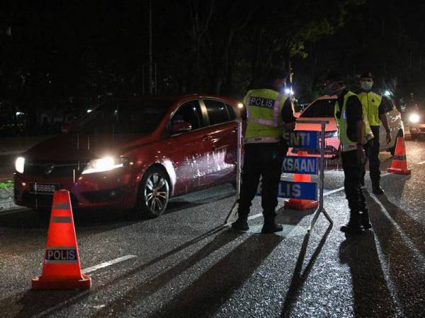 Anggota polis melakukan sekatan jalan raya susulan Perintah Kawalan Pergerakan selama 14 hari sehingga 31 Mac ini sebagai langkah pencegahan penularan Covid-19 di Jalan Ampang malam ini. -Foto Bernama