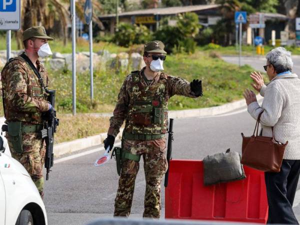 Tentera Itali menahan seorang wanita yang mahu memasuki negara itu dari Perancis di pintu sempadannya berhampiran bandar Menton, Perancis. - AFP