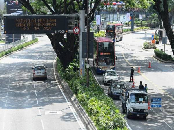 Anggota polis giat melakukan sekatan jalan raya susulan pelaksanaan Perintah Kawalan Pergerakan di seluruh negara selama 14 hari sejak 18 Mac lepas dalam usaha mencegah penularan baharu Covid-19 ketika tinjauan hari ini. - Foto Bernama