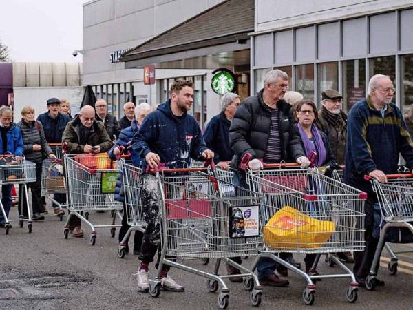 Orang ramai membuat pembelian panik di sebuah pasar raya di London akibat penularan Covid-19. - Foto Agensi