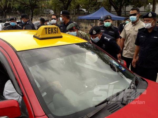 Ayob Khan (kanan) dan Zawai Adam melakukan pemeriksaan terhadap orang ramai dalam satu sekatan jalan raya yang dibuat pihak polis dengan kerjasama Angkatan Tentera Malaysia di Jalan Tampoi Lama, Johor Bahru, hari ini.