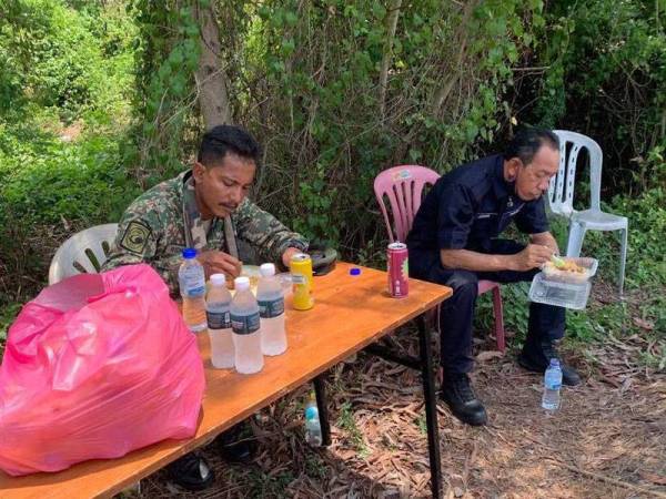 Anggota polis dan tentera yang bertugas menikmati sumbangan makanan yang diagihkan oleh pejabat Menteri Besar Kedah.