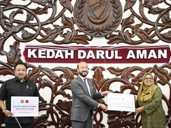 Mukhriz menyerahkan replika cek bernilai RM 430,000 kepada Dr. Shahrul Bariyah selepas mempengerusikan Mesyuarat Majlis Keselamatan Negara (MKN) peringkat Kedah di Wisma Darul Aman di sini, hari ini.