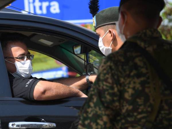 Anggota tentera di 4 Renjer Rejimen Sempadan Bukit Cowder membantu polis ketika mengadakan sekatan jalan raya. - Foto Bernama