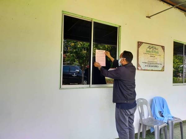 Kakitangan JHEAT yang bertugas sedang menampal notis pemberitahuan kepada jemaah di salah sebuah masjid Foto: ehsan JHEAT