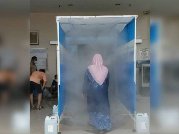 Seorang kakitangan Hospital Pakar KPJ Pulau Pinang melalui Terowong Sanitasi Mudah Alih setelah ia dipasang di hospital berkenaan baru-baru ini.