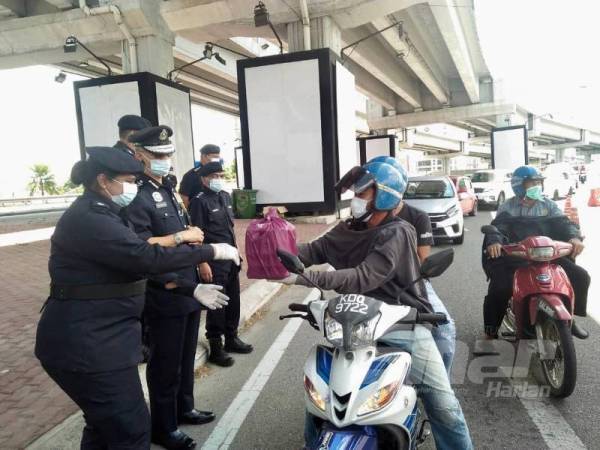 Hasanuddin (dua dari kanan) mengadakan rondaan dan lawatan ke sekatan jalan raya di bawah Jambatan Sultan Yahya Petra bagi menghadkan pergerakan orang ramai supaya mematuhi PKP yang dilaksanakan pihak kerajaan untuk memutuskan rantaian Covid-19.