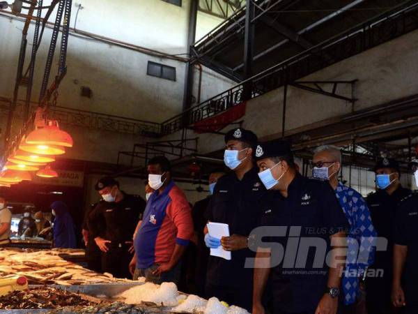 Ayob Khan (depan, kanan) meninjau keadaan di Pasar Borong Pandan, Johor Bahru hari ini bagi melihat tahap pematuhan orang ramai sebagai langkah berjaga-jaga dalam mencegah penularan wabak Covid-19.