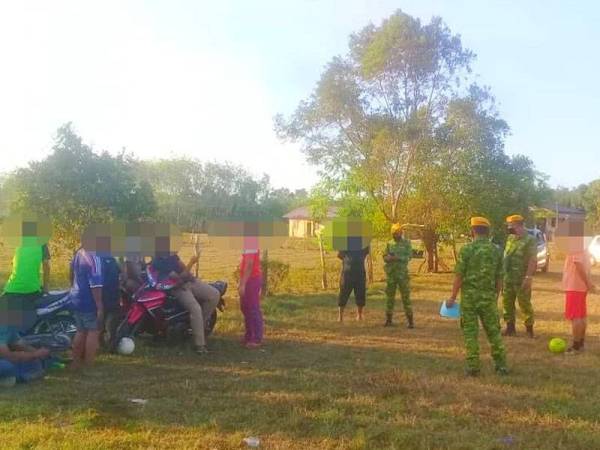 Anggota Rela Rantau Panjang menasihati sekumpulan anak-anak muda yang sedang bermain bola sepak di sebuah kampung di sini.