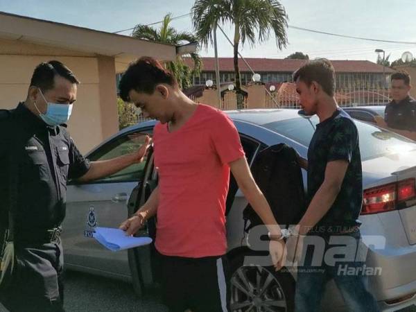 Chee Keng (kiri) dan Muhamad Saiful Izhar (kanan) tiba di Mahkamah Majistret Sungai Siput atas pertuduhan menghalang tugas polis hari ini.