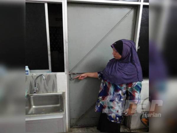 Azhani menunjukkan pintu dapurnya yang berdekatan dengan tingkap pintu gelongsor rumah sewanya yang dipercayai menjadi laluan pencuri melarikan diri.