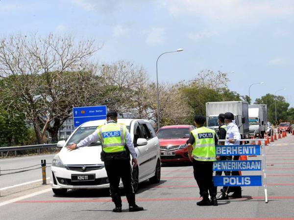 Anggota Polis membuat sekatan jalan raya dalam memastikan orang ramai mematuhi pelaksanaan Perintah Kawalan Pergerakan (PKP) ketika tinjauan di laluan keluar Plaza Tol Alor Setar Selatan di sini. - FOTO: BERNAMA