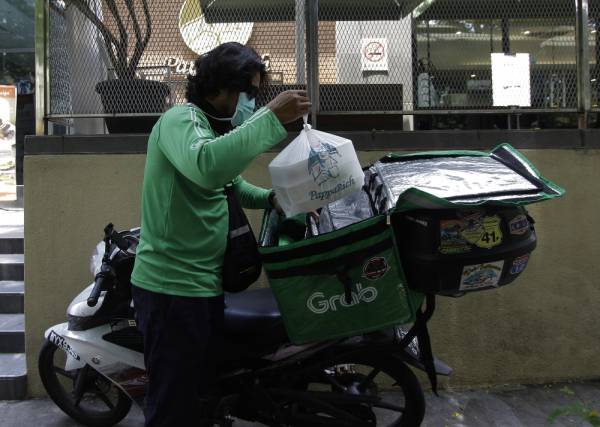 Seorang pekerja penghantar makanan membeli makanan yang dibungkus untuk dihantar ke pelanggan. -Foto Bernama