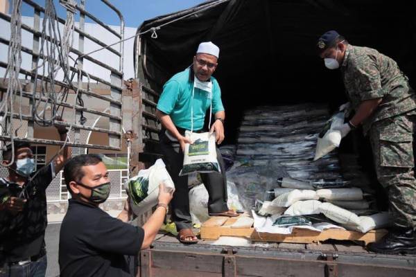 Syeikh Zakaria (tengah) bersama petugas LZNK dengan kerjasama Rejimen 513 Askar Wataniah (AW) Kem Bukit Pinang mengagihkan bekalan makanan tambahan 'Food Bank Zakat Kedah' di masjid-masjid dalam daerah Kota Setar, Selasa lalu.