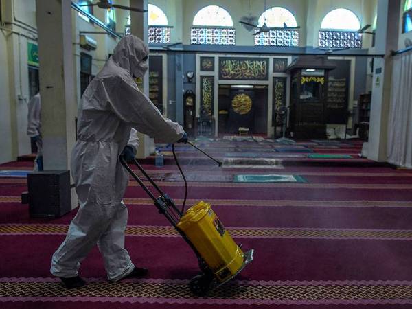 Seorang kakitangan dari syarikat swasta menjalankan proses penyahkuman atau disinfeksi di seluruh Surau Taman Setapak Jaya Jalan Tun Razak. - Foto Bernama