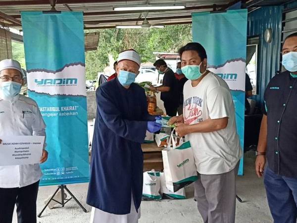 Zukifli (dua dari kiri) menyampaikan sumbangan kepada golongan memerlukan dalam kempen Musaádah Covid-19.