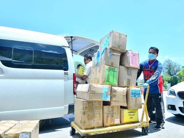 Sukarelawan memunggah barangan kelengkapan perlindungan diri yang diterima daripada pembekal di Pusat Operasi Sinar Untuk Frontliners Covid-19 di Kumpulan Karangkraf.