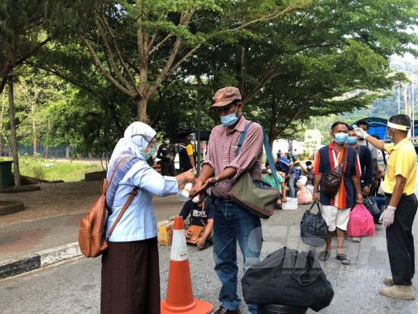 Rakyat Thailand diberi cecair pembasmi kuman sebelum dibenarkan melepasi sempadan untuk pulang ke negara itu. 