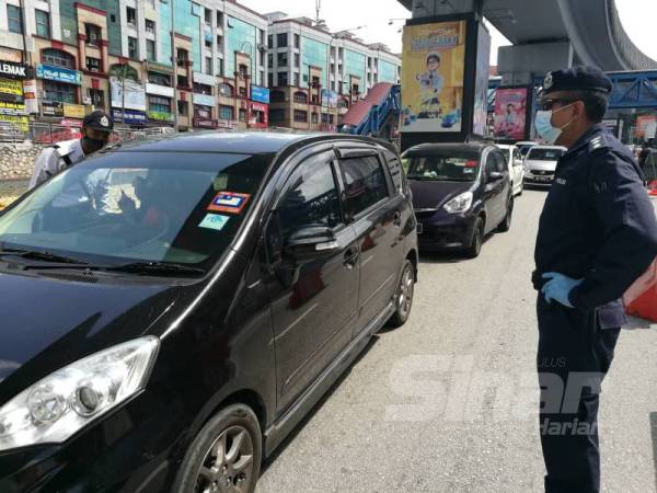 Nik Ezanee sedang meninjau sekatan jalan raya di Jalan Persiaran Surian, Damansara, hari ini.