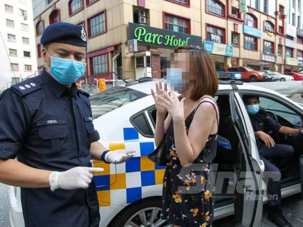 Seorang wanita ditahan kerana ingkar arahan ketika sekatan jalan raya Ops Covid-19 di Persiaran Surian, Damansara. - FOTO SHARIFUDIN ABDUL RAHIM