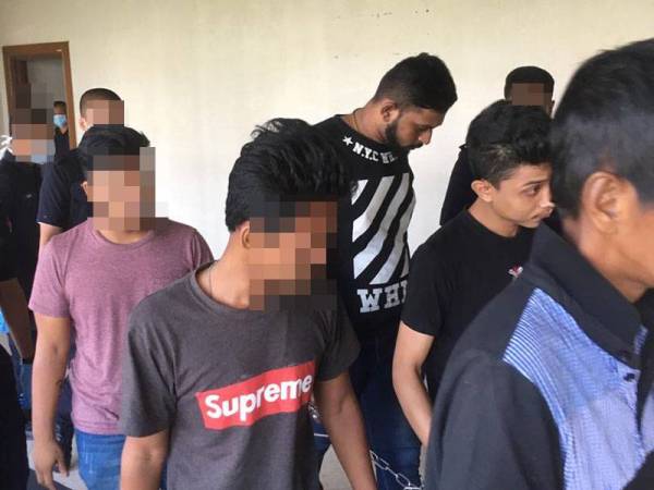 Dua tertuduh (depan, kanan) dan (baju hitam berbelang) dipenjara lapan bulan dan empat minggu selepas mengaku bersalah menyamar sebagai anggota polis dan langgar arahan PKP.