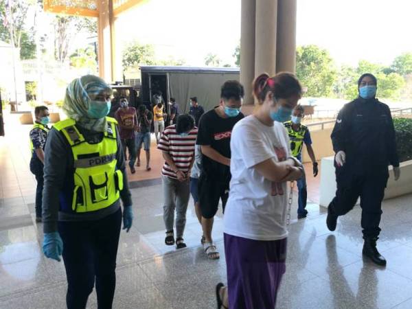 Tertuduh diiringi anggota polis ketika dibawa untuk mendengar sebutan kes di Mahkamah Majistret di sini hari ini.