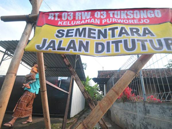 Kebanyakan kerajaan tempatan melaksanakan langkah kuarantin sendiri untuk mengelakkan penularan Covid-19 di Purworejo, Jawa Tengah. - Foto AFP