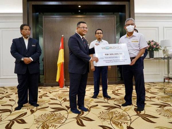 Rosli (kanan) menyampaikan sumbangan inisiatif Worldwide Prihatin bagi menangani penularan wabak Covid-19 kepada Menteri Besar Selangor, Datuk Seri Amirudin Shari di Kediaman Rasmi Menteri Besar Selangor semalam.