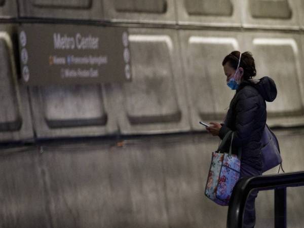 Seorang penduduk yang melakai topeng muka di stesen metro di Washington D.C. Foto: Xinhua