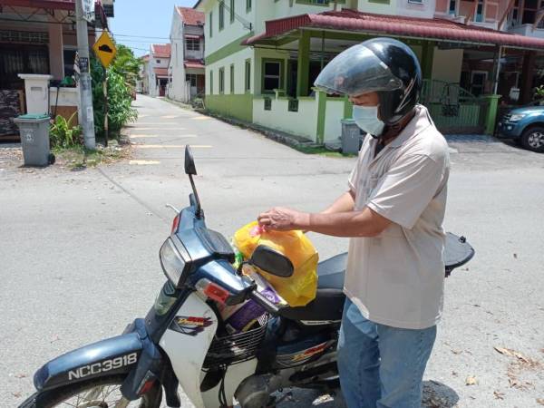 Saudara baru, Choo Poo Kim, 54, ketika mengambil barangan sumbangan Perkasih N9 selepas barangan makanan habis di rumahnya di Kampung Sri Parit, Lukut, Port Dickson.