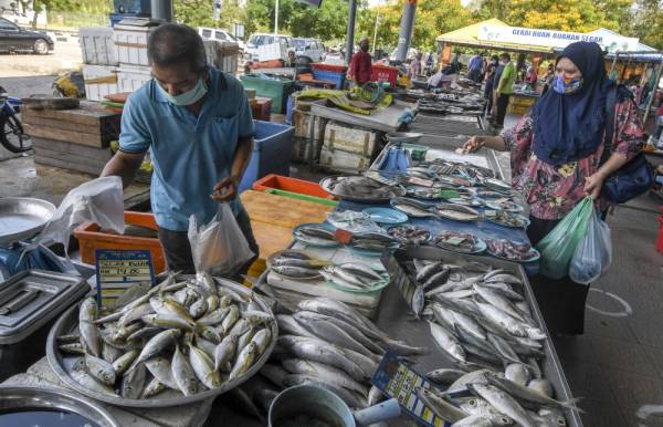 Orang ramai dilihat membeli barangan keperluan harian seperti biasa susulan tempoh Perintah Kawalan Pergerakan. -Foto Bernama