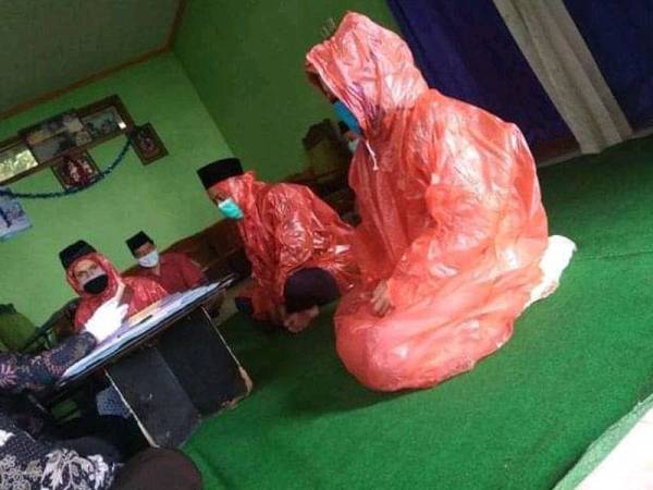 Mempelai pakai baju hujan ketika akad nikah. -Foto Twitter @NoviaFm