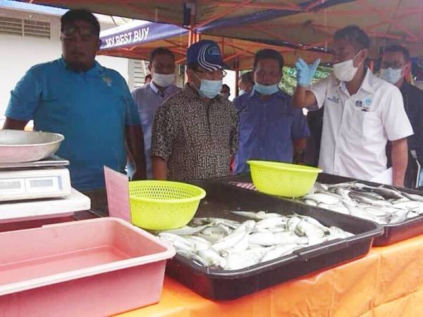 Ahmad (dua dari kiri) melihat barangan basah di pusat jualan barangan segar terkawal di Pejabat FAMA Melaka di Kawasan Perindustrian Ayer Keroh hari ini.