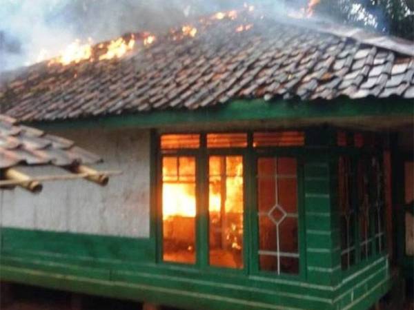 Sebuah rumah terbakar di Kampung Sukaraja daerah Cianjur. -Foto Kompas