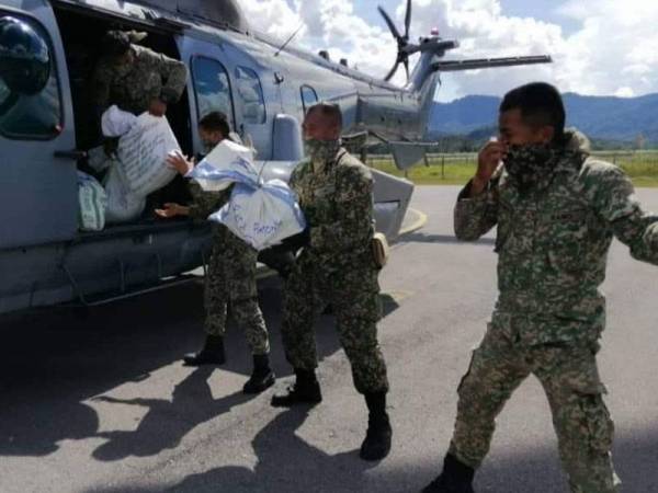 Anggota ATM sedang memasukan bekalan makanan ke dalam helikopter.