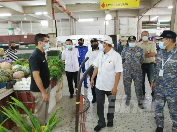 Abd Rahim (tengah) mengadakan lawatan ke Pasar Besar Kuantan bagi melihat pematuhan peniaga dan pengunjung bagi mengelak jangkitan Covid-19 di sini hari ini. 