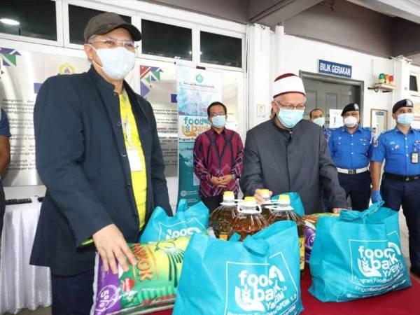 Simbolik penyerahan sumbangan pek makanan kepada penduduk Menara City One oleh Zulkifli (kanan) kepada Annuar di CMC, Bahagian Penguatkuasaan Dewan Bandaraya Kuala Lumpur (DBKL) hari ini.