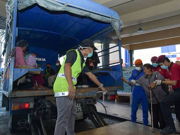 Seorang gelandangan yang lumpuh kaki kanan dibantu untuk naik ke atas lori selepas ditahan dalam satu operasi di Stesen Bas Majlis Bandaraya Kuala Terengganu, semalam. - Foto Bernama