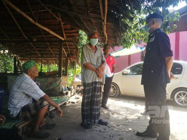 Zainuddin (kanan) menziarahi Ahmad Awang Kecil,77, (tengah) yang merupakan bapa kepada mangsa penahan petir di Kampung Hujung Bechah, Sik, hari ini.