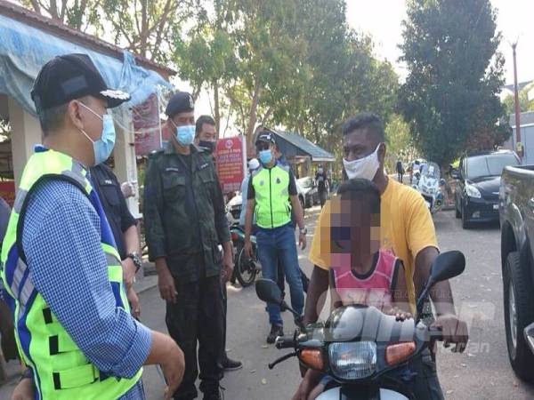 Sharul Lalli (kiri) ketika memberi nasihat kepada tiga beranak itu berhampiran Jeti Nelayan Pantai Siring,Serkam di sini, pagi tadi.