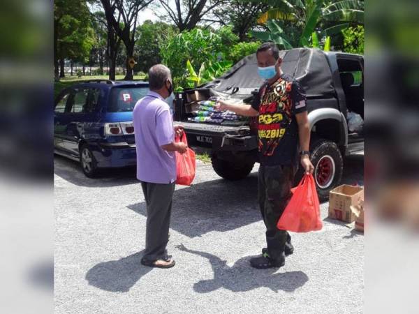 Fauzi (kanan) menghulurkan bantuan kepada mereka yang kurang berkemampuan.