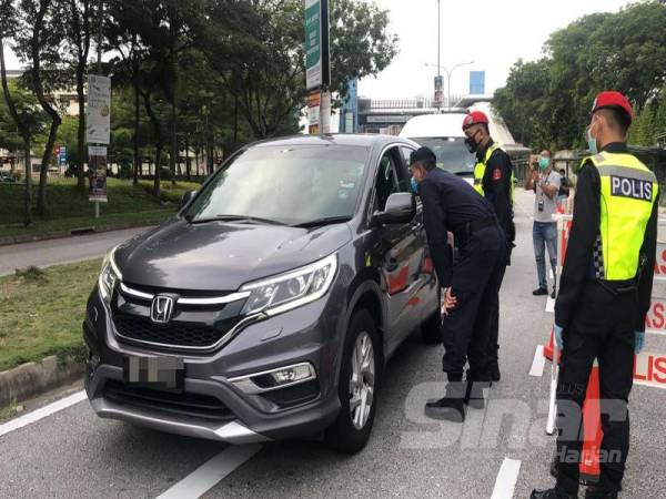 
Nik Ezanee memeriksa pengguna jalan raya yang melalui sekatan jalan raya di Jalan PJU 7/1 Mutiara Damansara, Petaling Jaya, Selangor, hari ini.