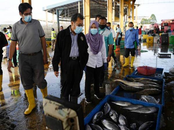 Timbalan Menteri Pertanian dan Industri Asas Makanan II Datuk Che Abdullah Mat Nawi (dua, kiri) melihat ikan yang baru dinaikkan ketika lawatan kerja di Kompleks Lembaga Kemajuan Ikan Malaysia (LKIM) hari ini. - Foto Bernama
