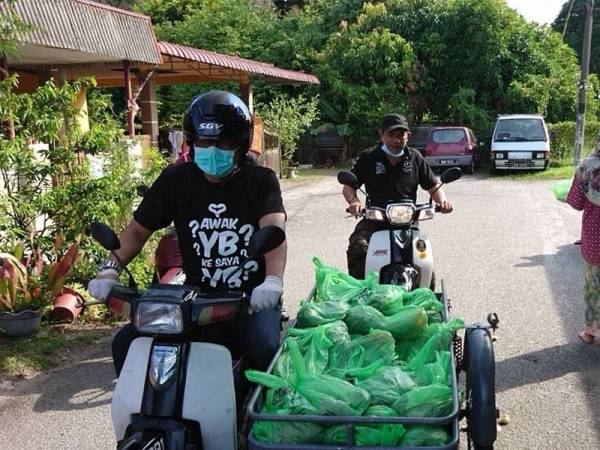 Norhizam menunggang motosikal roda tiga membawa barangan basah untuk diagihkan kepada penduduk terpilih di Rumah Awam 1 Taman Pulau Gadong hari ini.