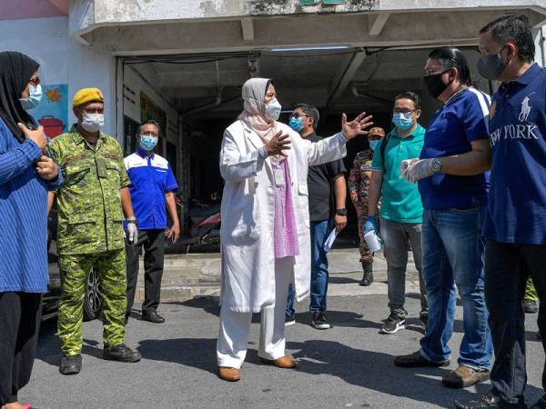 Menteri Perumahan dan Kerajaan Tempatan Zuraida Kamaruddin memberikan penerangan kepada sebahagian penduduk Flat Taman Kosas ketika meninjau Operasi Sanitasi Awam Covid-19 di kawasan itu hari ini. - fotoBERNAMA