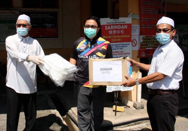 Timbalan Menteri Kesihatan Datuk Dr Noor Azmi Ghazali (kanan) menyerahkan Peralatan Pelindungan Diri (PPE) dan topeng muka kepada Pembantu Perubatan Nizam Yaakub di Pusat Kesihatan Alor Pongsu hari ini. -Foto Bernama