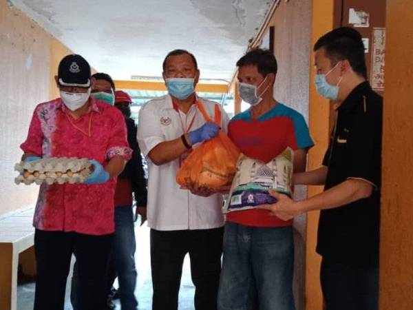 Saharuddin (dua dari kiri) menyampaikan sumbangan barangan makanan dan keperluan harian kepada salah seorang wakil keluarga memerlukan di PPR Maluri, Cheras hari ini. -Foto SHARIFUDIN ABDUL RAHIM