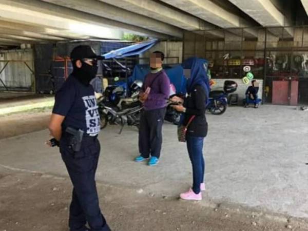 Anggota bertugas (kiri) sedang menyoal siasat dua individu yang ditahan melakukan COD untuk pemeriksaan lanjut -Foto: ihsan Facebook IPD Kemaman