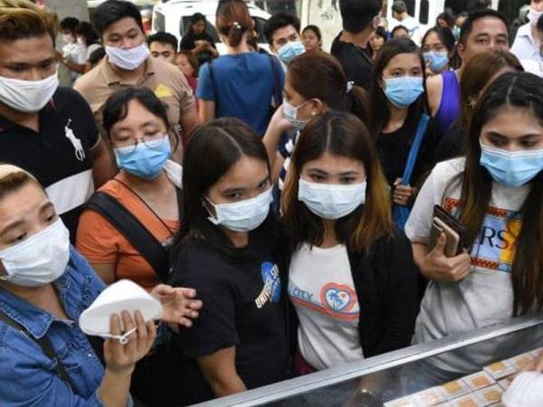 Rakyat Filipina sedang membeli topeng penutup muka. -Foto AFP